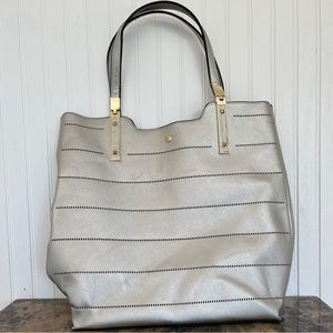Large, silver purse/ tote bag with gold accents and black interior